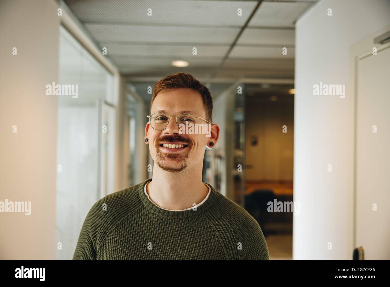 Porträt einer glücklichen männlichen Führungskraft im Büro. Fröhlicher Geschäftsmann im Coworking Space. Stockfoto