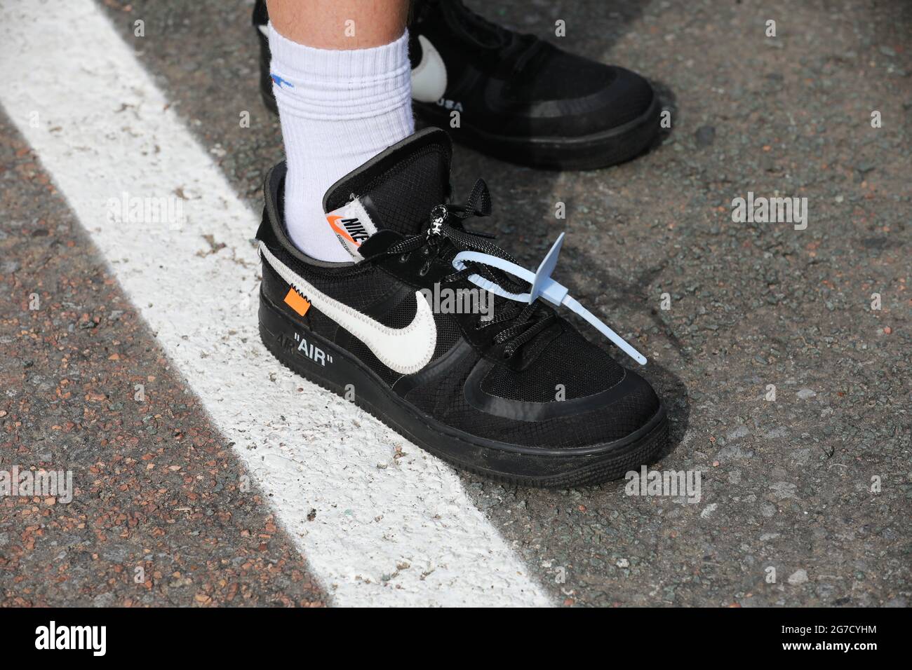 Ein junger Teenager, der in Leeds, West Yorkshire, Großbritannien, Nike Air Sportschuhe mit einem Plastikanhänger trägt, der auf ihnen als modisches Statement zurückgelassen wurde. Stockfoto