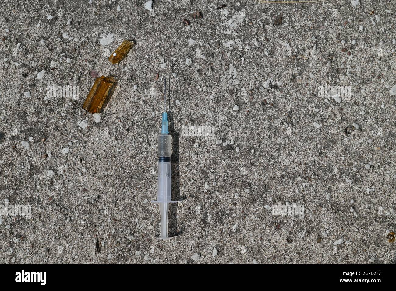 Ampulle mit Injektion und Spritze auf grauem Steingrund Stockfoto