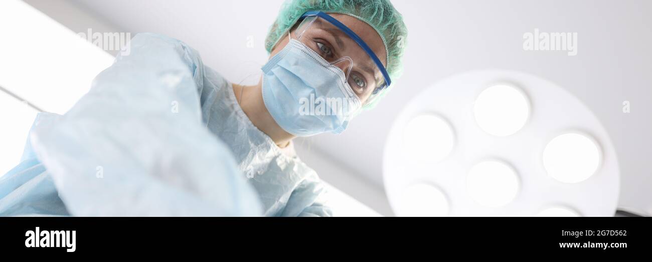 Frau Chirurg tut Herzmassage für Patienten im Operationssaal Stockfoto