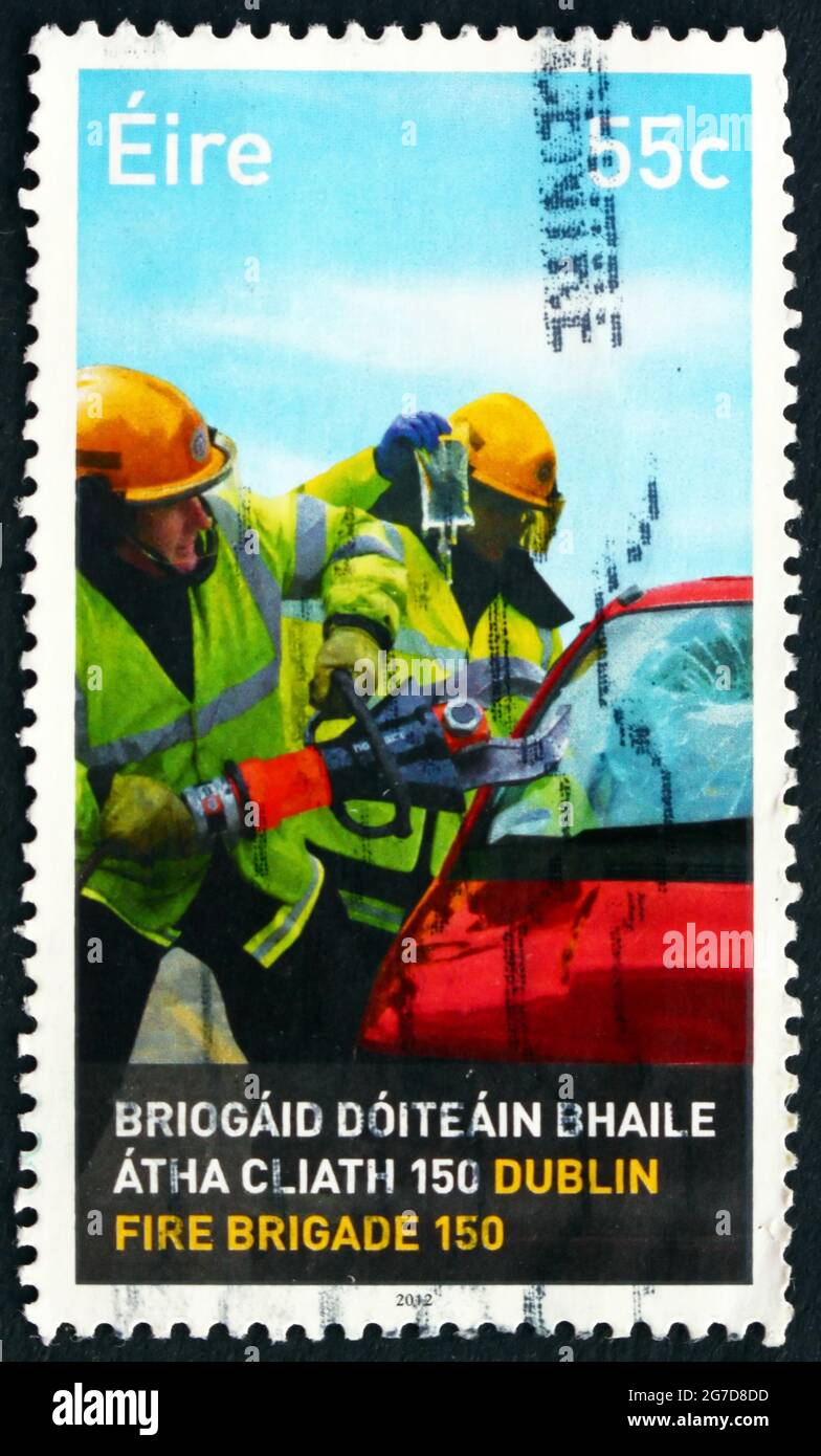 IRLAND - UM 2012: Eine in Irland gedruckte Marke zeigt Feuerwehrleute, die Verletzte aus dem Auto extrahieren, 150. Jahrestag Feuerwehr, Dublin, um 201 Stockfoto