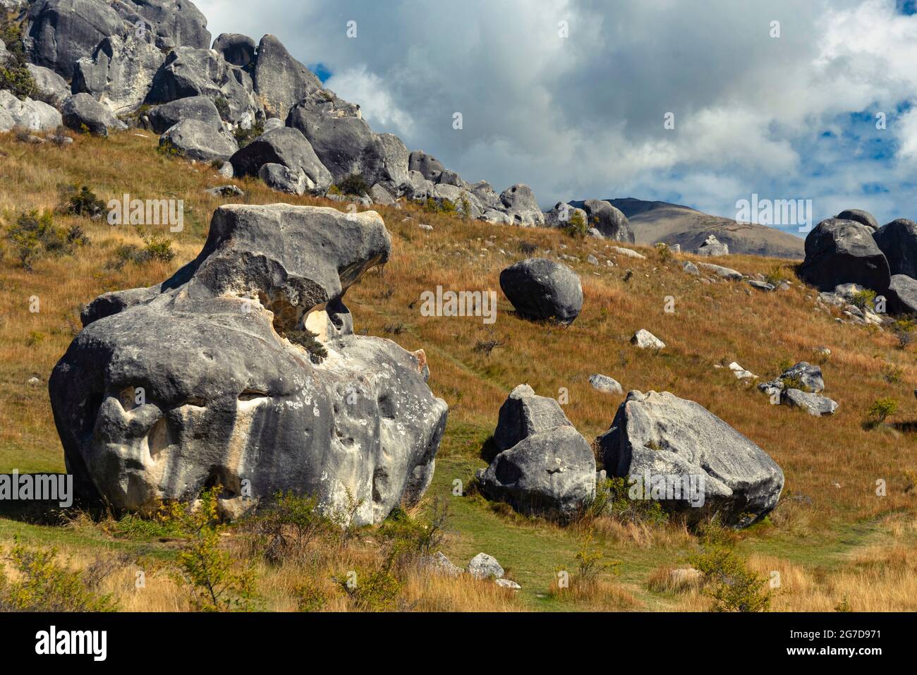 Atemberaubende Felsbrocken auf Castle Hill, Neuseeland. Blauer, wolkig bewachsener Himmel, goldenes Grasland, die Berge der südlichen alpen umraenkend. Arthur's Pass Stockfoto
