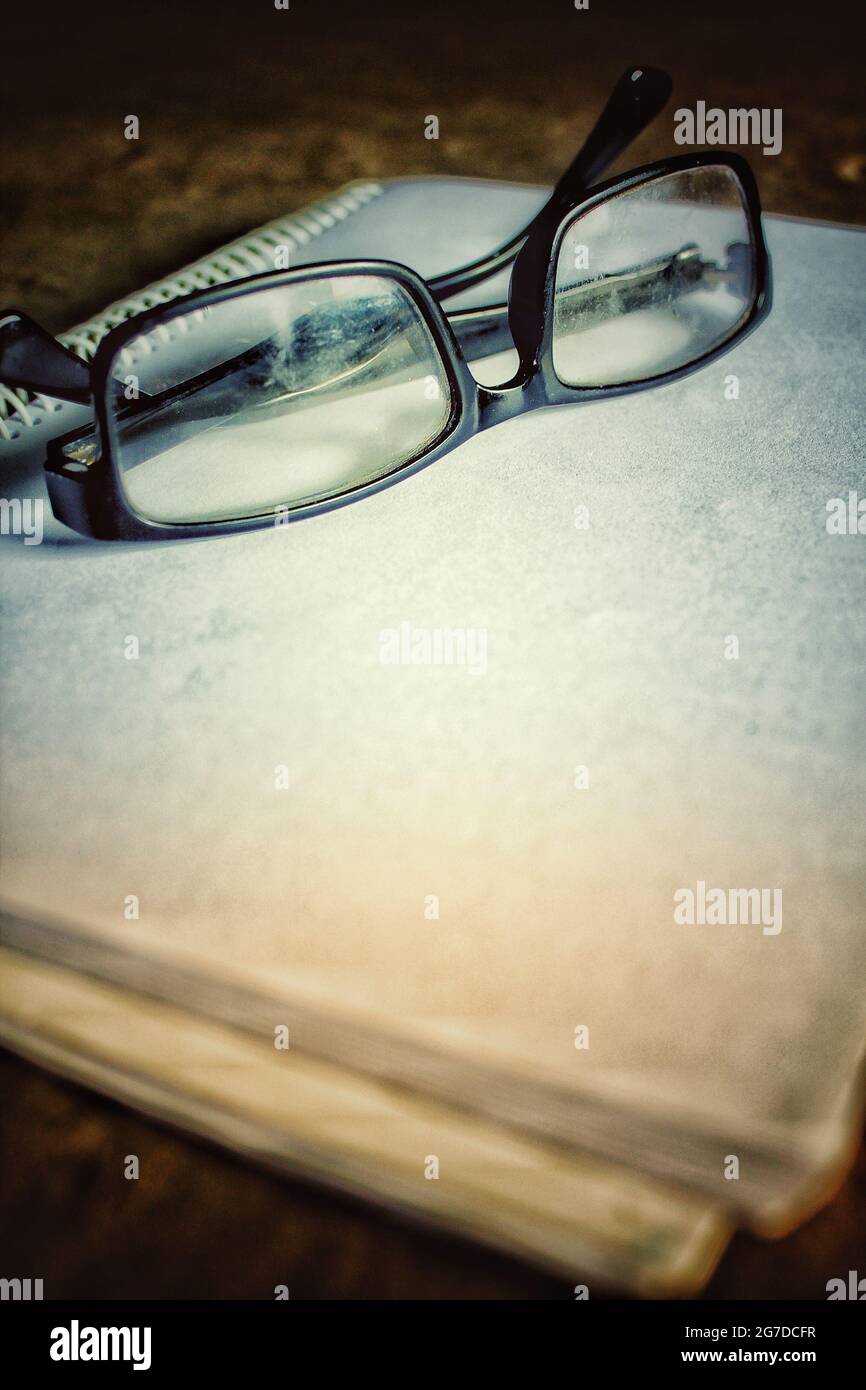 Brillenbrille auf weißem Übungsbuch, Brillenbild Stockfoto