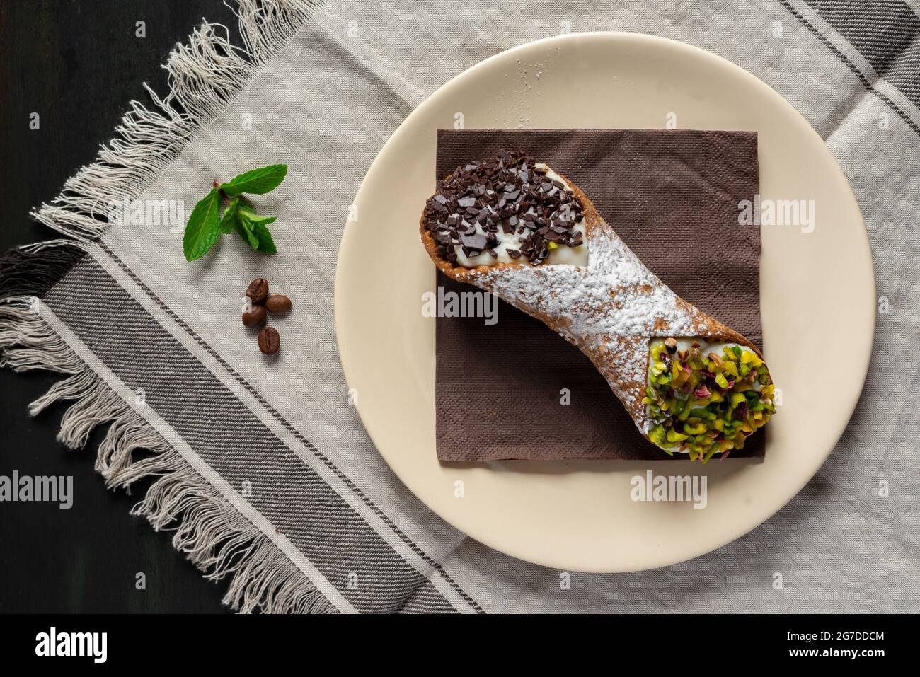 Süße Cannoli siciliani gefüllt mit Ricotta-Käse und Zucker mit Pistazien und Schokoladentropfen Stockfoto