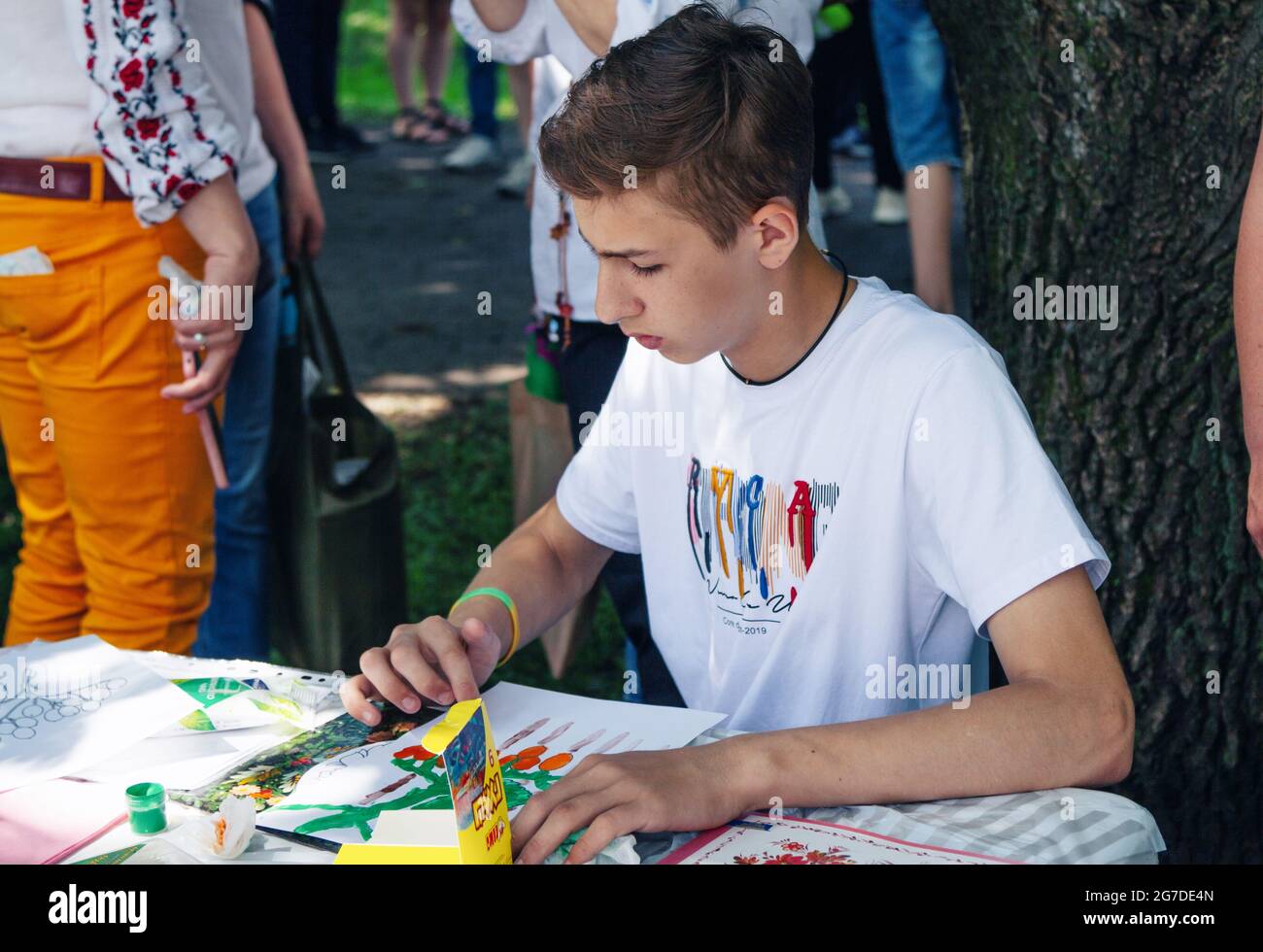 Zaporizhia, Ukraine- 19. Juni 2021: Charity Familienfest: Junge Teilnahme an Kunst und Handwerk im Freien Workshop, machen bunte Zeichnung mit Gouac Stockfoto