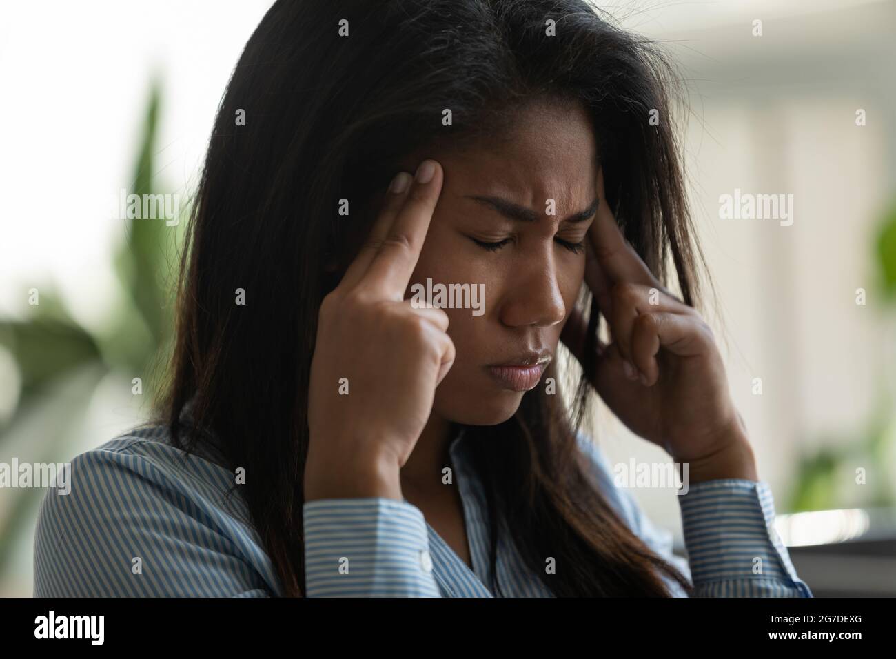 Frustriert gemischte Rasse Asiatische Büroangestellte Gefühl schmerzhafte Migräne Stockfoto