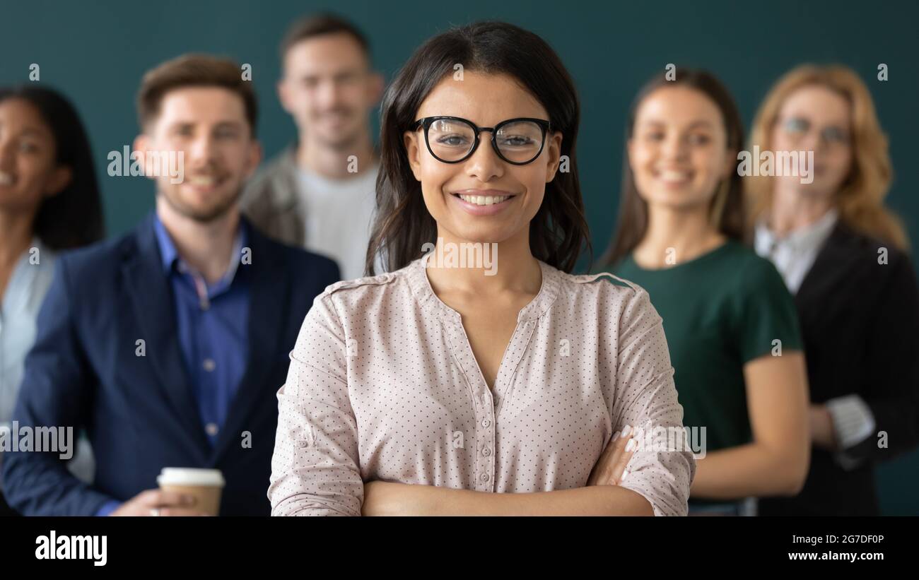 Glückliche weibliche Geschäftsführerin, die vor dem Team steht Stockfoto