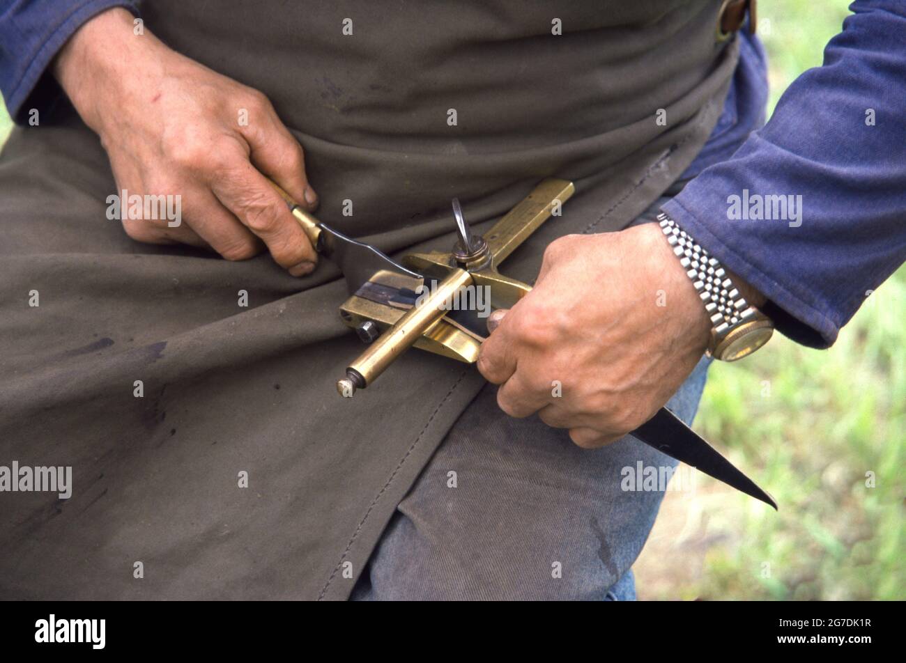 Handarbeit Schneiden von Leder mit alten Werkzeugen Stockfoto