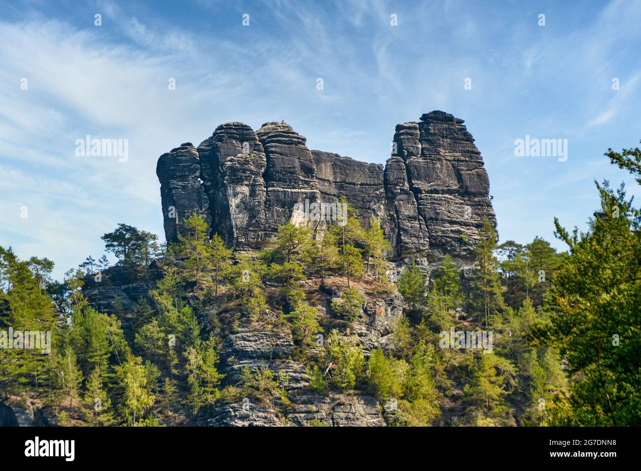 Sandsteinfelsen-Formation die Lokomotive in der Deutsch-Sächsischen Schweiz mit blauem Himmel im schönen grünen Elbtal. Ein Kletterer klettert auf die r Stockfoto