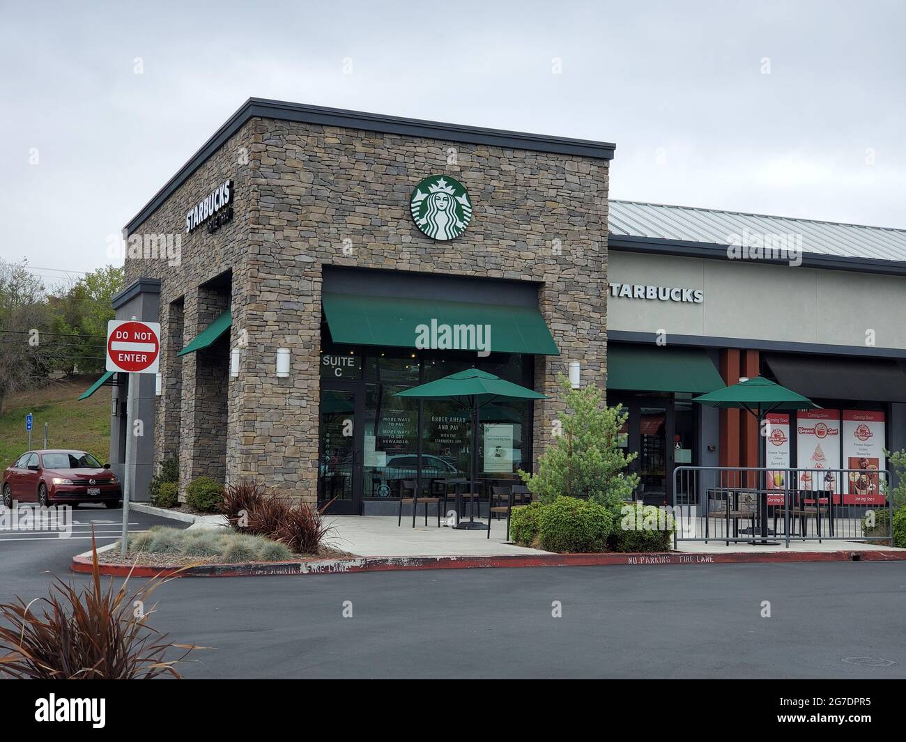 Vorderansicht des Eingangs zu einem Starbucks Coffee Shop mit der Beschilderung des Unternehmens oben in Walnut Creek, Kalifornien, 25. April 2021. () Stockfoto