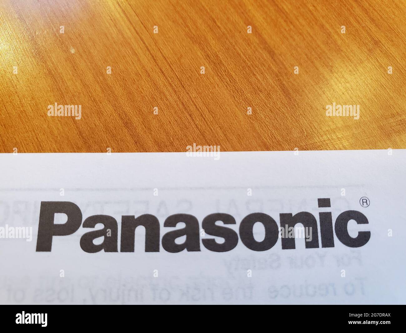 Nahaufnahme eines schwarzen Panasonic-Logos auf weißem Hintergrund, das auf einer Holzfurnier-Oberfläche aufliegt, aufgenommen in Lafayette, Kalifornien, 30. April 2021. () Stockfoto