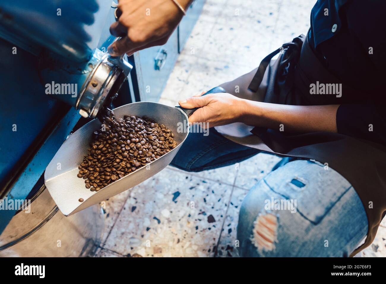 Frau nimmt Kaffeebohnen aus dem Lager, um sie zu verkaufen Stockfoto