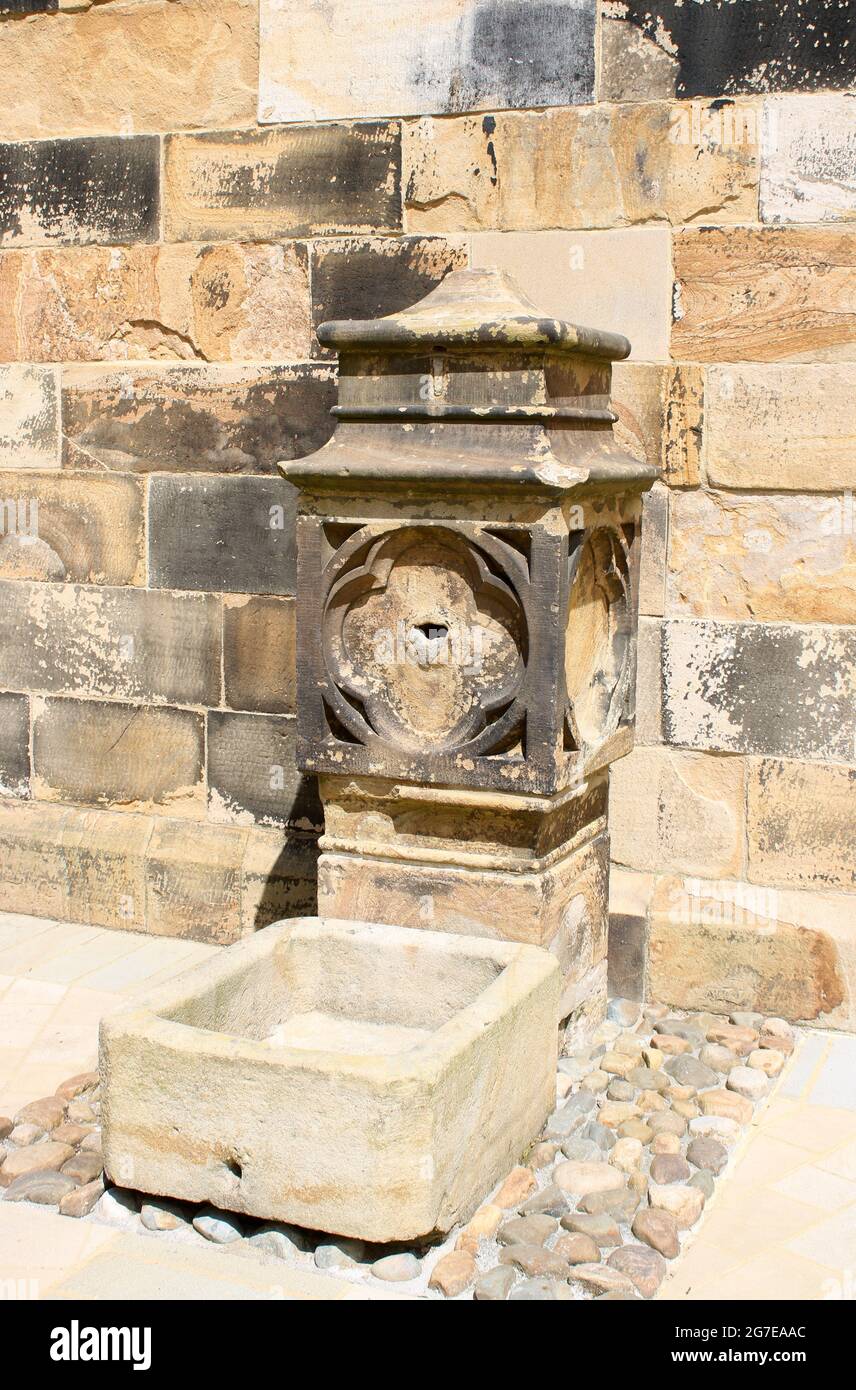 Historischer kunstvoller alter Steinbrunnen und Wassertrog (nicht in Gebrauch) im Innenhof Lancaster Castle, Lancaster, Lancashire, England. Stockfoto