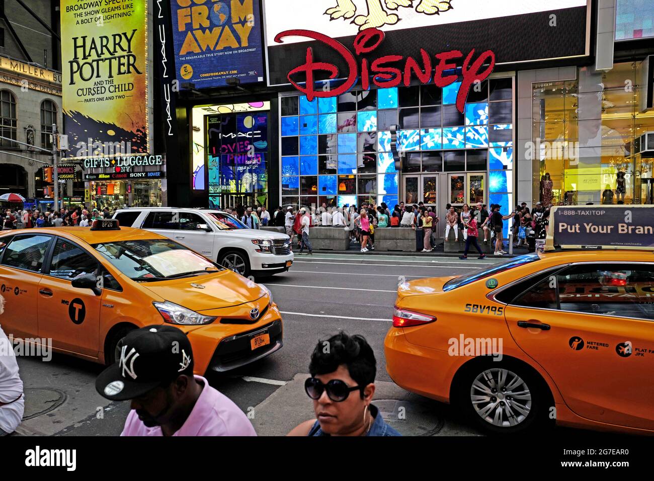 Disney-Laden und gelbe Taxis am Times Square in Manhattan, in New York City. Stockfoto