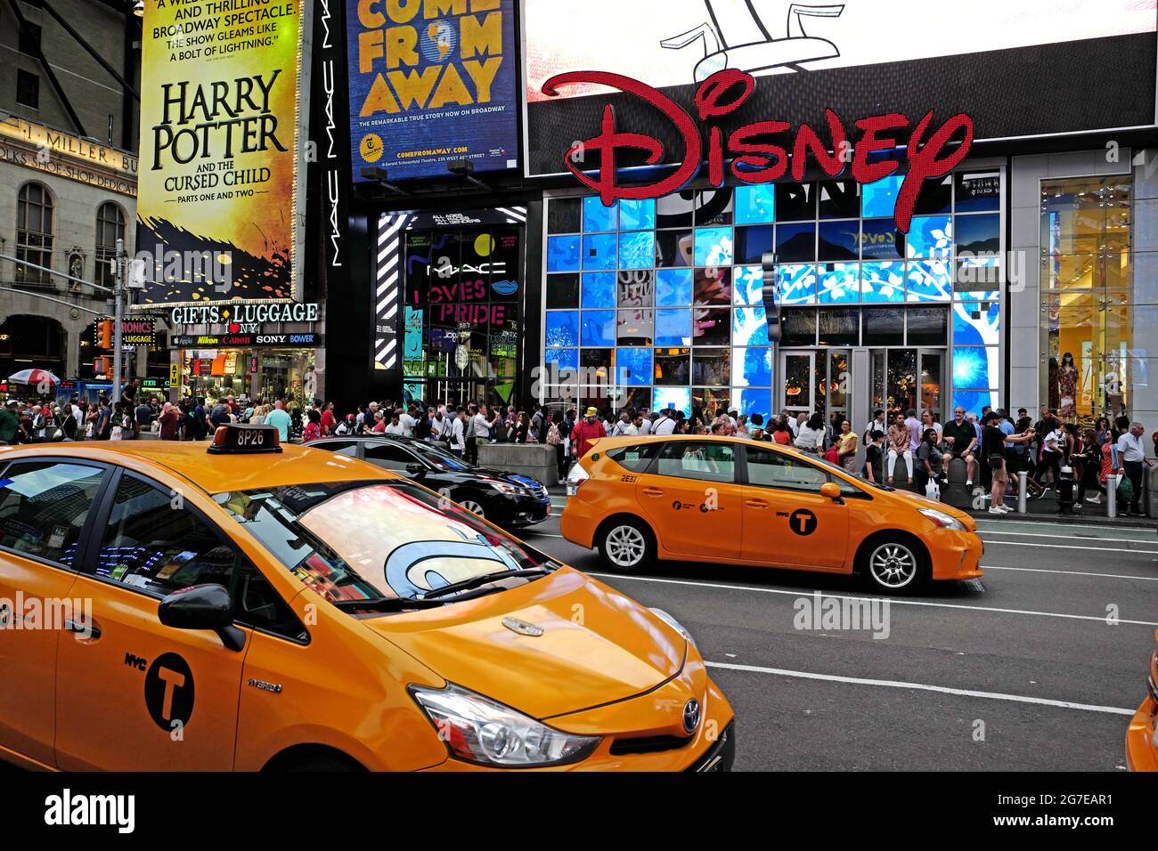 Disney-Laden und gelbe Taxis am Times Square in Manhattan, in New York City. Stockfoto