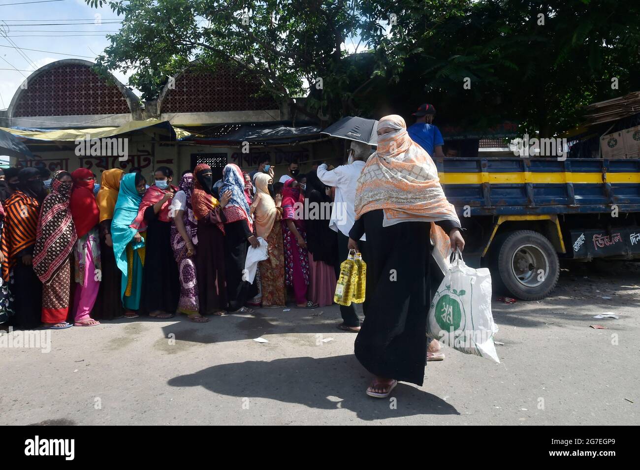 Dhaka. Juli 2021. Eine Frau verlässt das Geschäft, nachdem sie am 13. Juli 2021 in einem von der Regierung betriebenen, preisgünstigen Mobilfunkgeschäft in Dhaka, Bangladesch, einkaufen ging. Die Regierung von Bangladesch hat fünf Pakete von 32 Milliarden Taka (etwa 372 Millionen US-Dollar) angekündigt, um einkommensschwachen Gruppen zu helfen, die von der Sperrung der COVID-19-Pandemie betroffen sind. Quelle: Xinhua/Alamy Live News Stockfoto