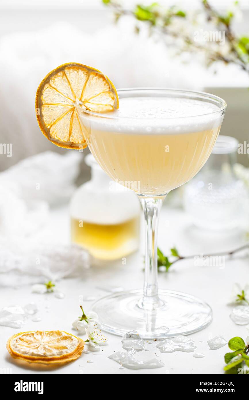 Ein Gin-Sour mit Bergamotte und Kamille, garniert mit Eiweiß-Schaum und einer Scheibe getrockneter Zitrone Stockfoto