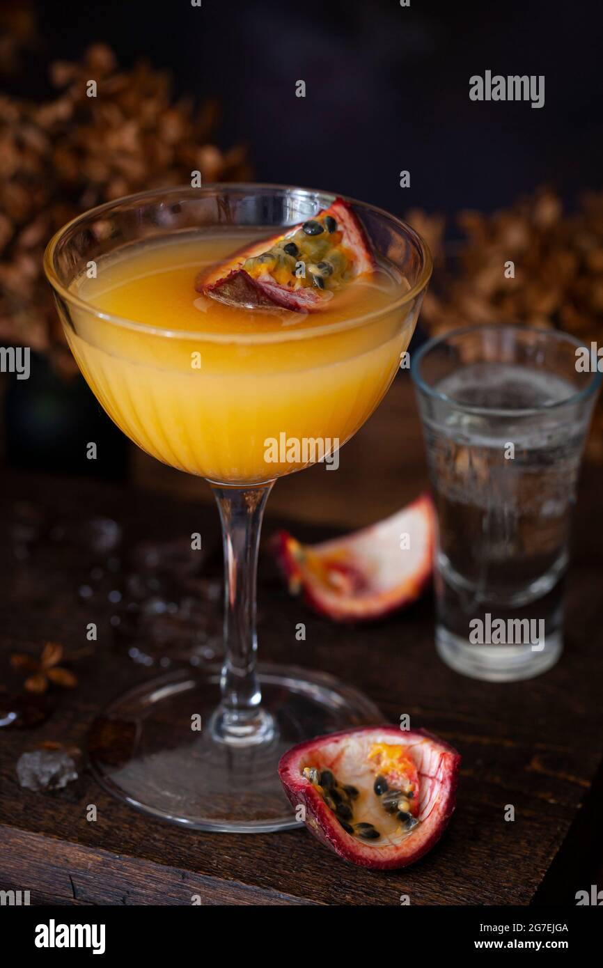 Ein Passionsfrucht-martini (Maverick), gekrönt mit einem Viertel Passionsfrucht und serviert mit Sekt Stockfoto