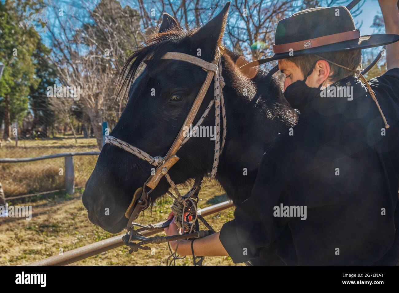 Nahaufnahme eines argentinischen Reiters, der sich darauf vorbereitet, ein Pferd auf einem Feld zu reiten Stockfoto