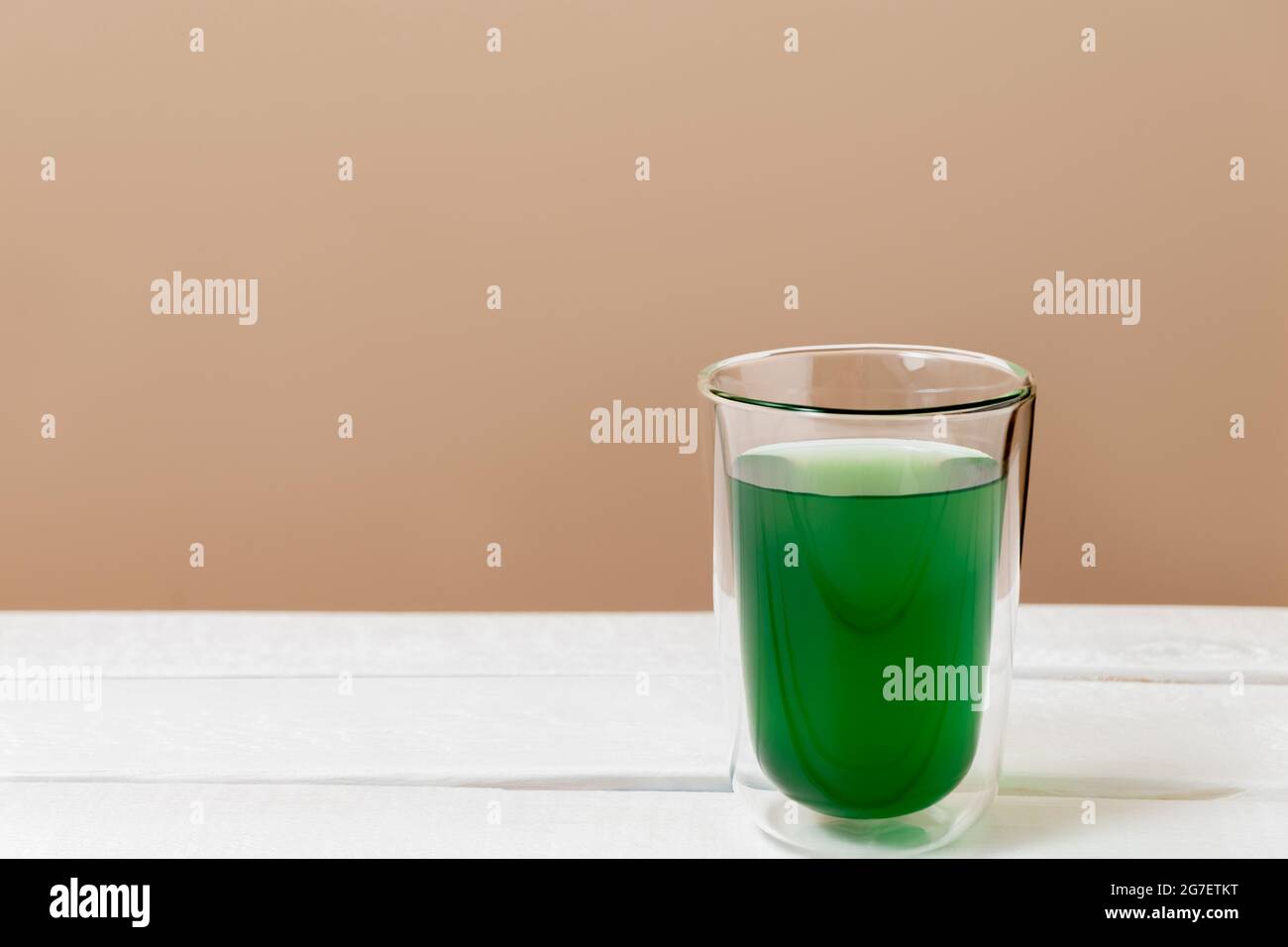 Grünes Chlorophyll-Getränk in einem Glas auf weißem Tisch mit Kopierfläche Stockfoto