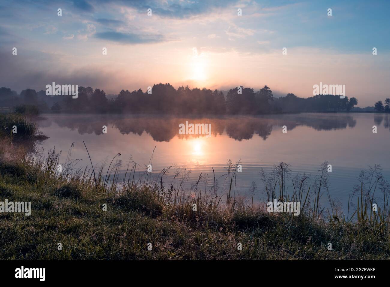 Schöner Sonnenaufgang am See, umgeben von Wald in Krasnobród, Roztocze, Polen. Stockfoto