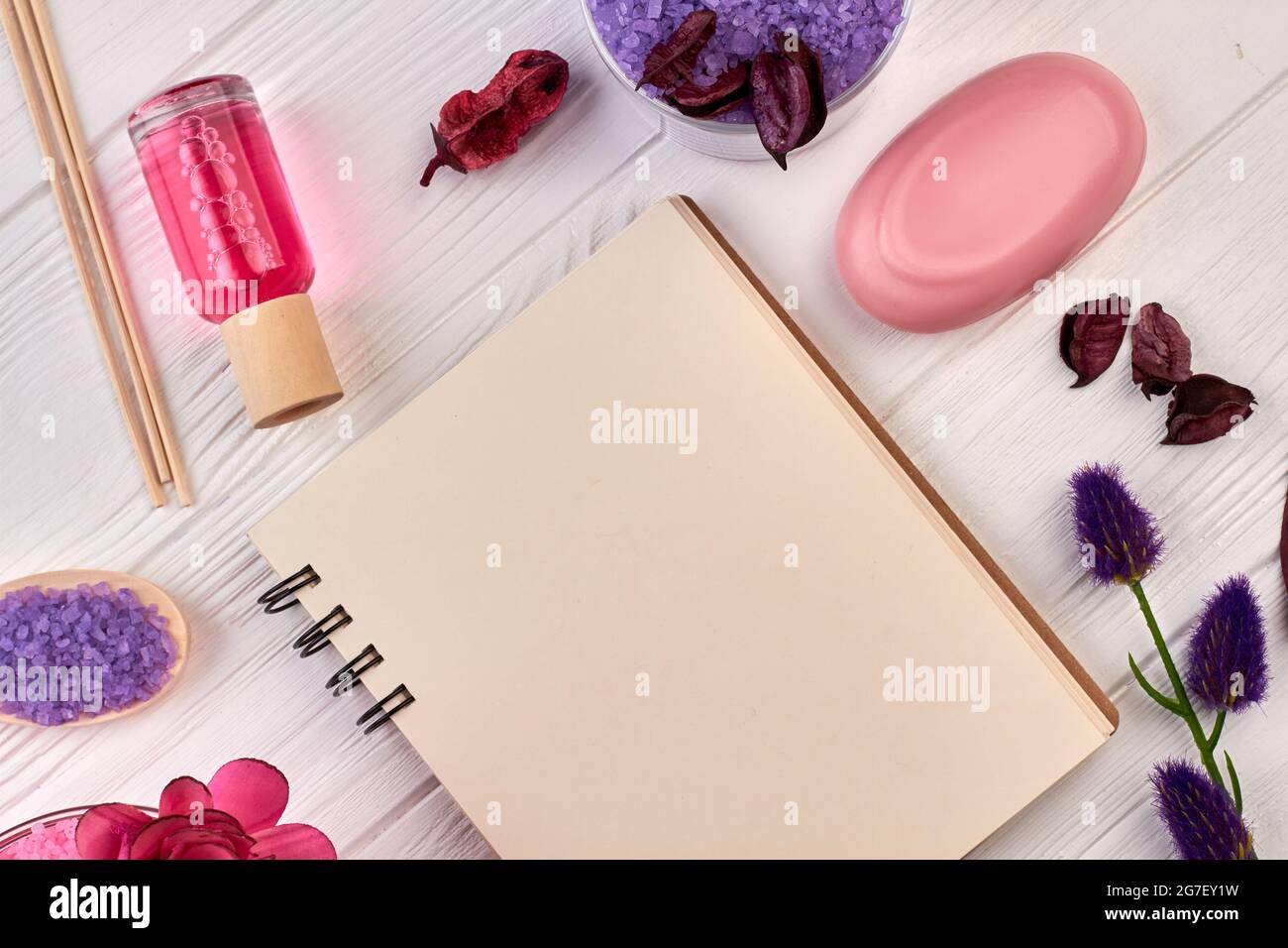 Notizblock und Spa-Behandlungen auf weißem Holz. Stockfoto