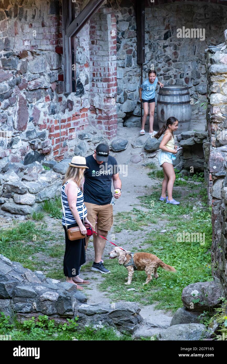 Familie mit Hund bei der Erkundung der Ruinen von Schloss Raseborg im Innenhof in Raasepori, Finnland Stockfoto