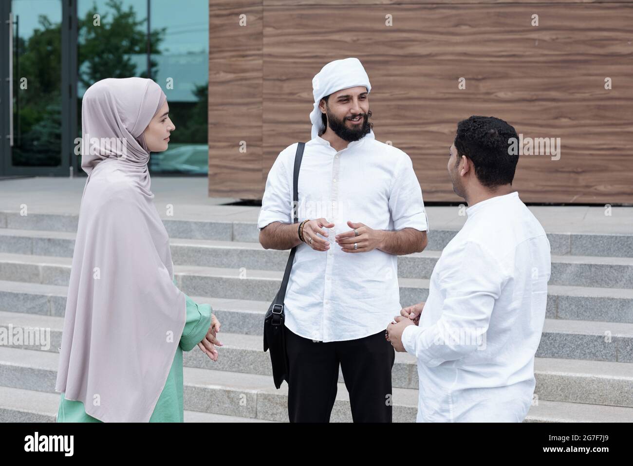 Gruppe islamischer Studenten, die im Kreis stehen und nach dem Unterricht über Projektideen diskutieren Stockfoto