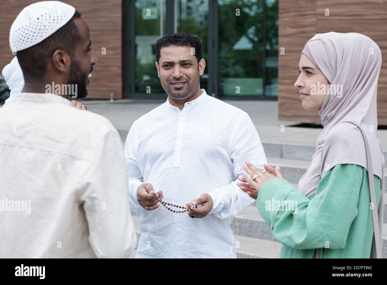Gruppe von Inhalten ehrgeizige junge islamische Geschäftsleute stehen im Kreis im Freien und diskutieren Entwicklung des Geschäfts Stockfoto