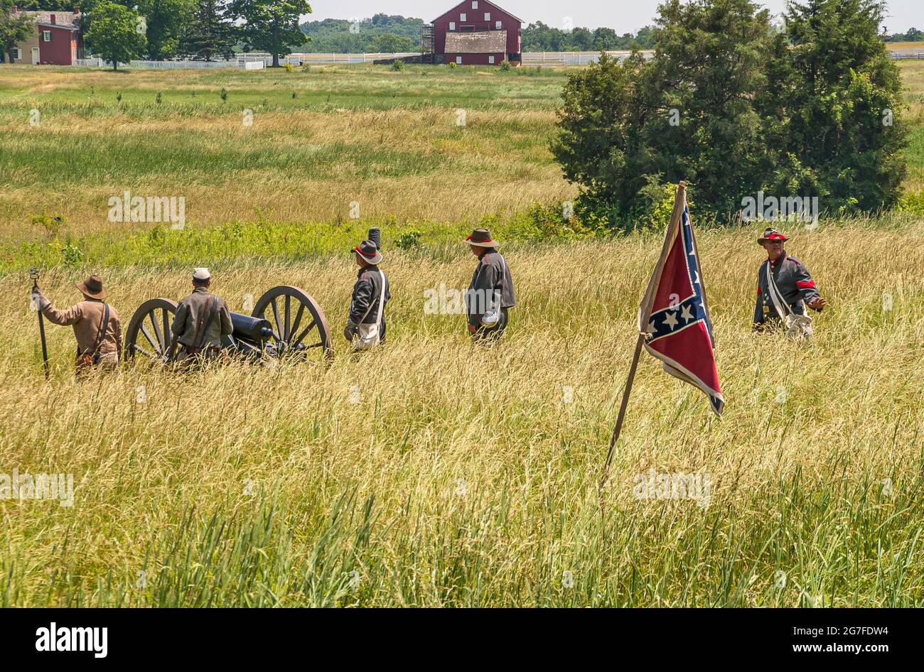 Gettysburg, PA, USA - 14. Juni 2008: Schlachtfelddenkmäler. Landschaft mit Männergruppe mit konföderierten Flaggen, die Kriegskulisse vorführen, beige yel Stockfoto