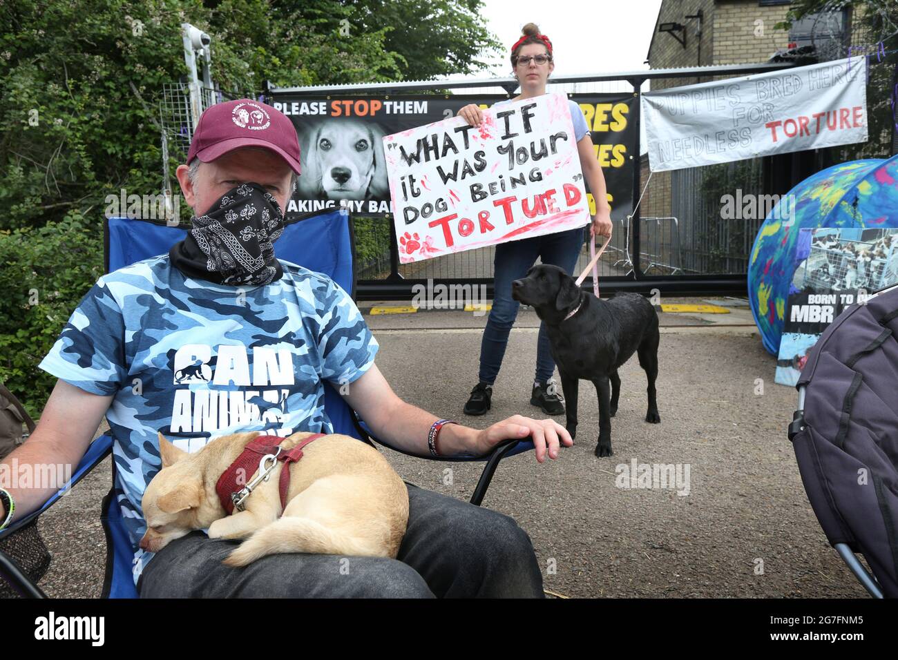 Huntingdon, Großbritannien. Juli 2021. Aktivisten mit ihren Hunden werden während der Demonstration vor den Fabriktoren gesehen.Tierrechtler besetzen das Camp Beagle, ein Protestlager am Straßenrand vor dem Beagle-Züchter Marshal Bioresourcen (MBR) Acres. Ihre Welpen wurden an Tierversuchslabors verkauft. Die Aktivisten werden vor der Fabrik campen, bis sie geschlossen und alle Beagle frei sind. (Foto von Martin Pope/SOPA Images/Sipa USA) Quelle: SIPA USA/Alamy Live News Stockfoto
