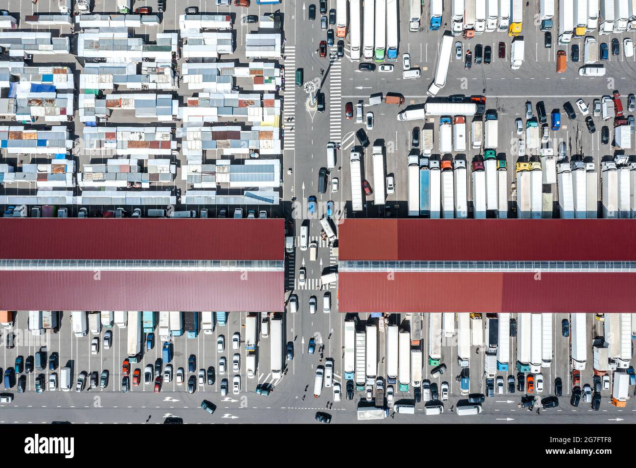 Luftaufnahme des Großhandelsmarktes für Landwirte. Viele Anhänger-Lastwagen an Lagerdocks. Stockfoto