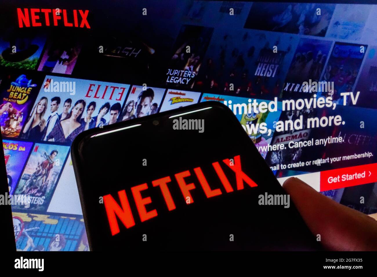 SAO PAULO, BRASILIEN - 03. Juli 2021: Netflix-Logo auf dem Smartphone-Bildschirm sichtbar, und Website-Homepage im Hintergrund Stockfoto