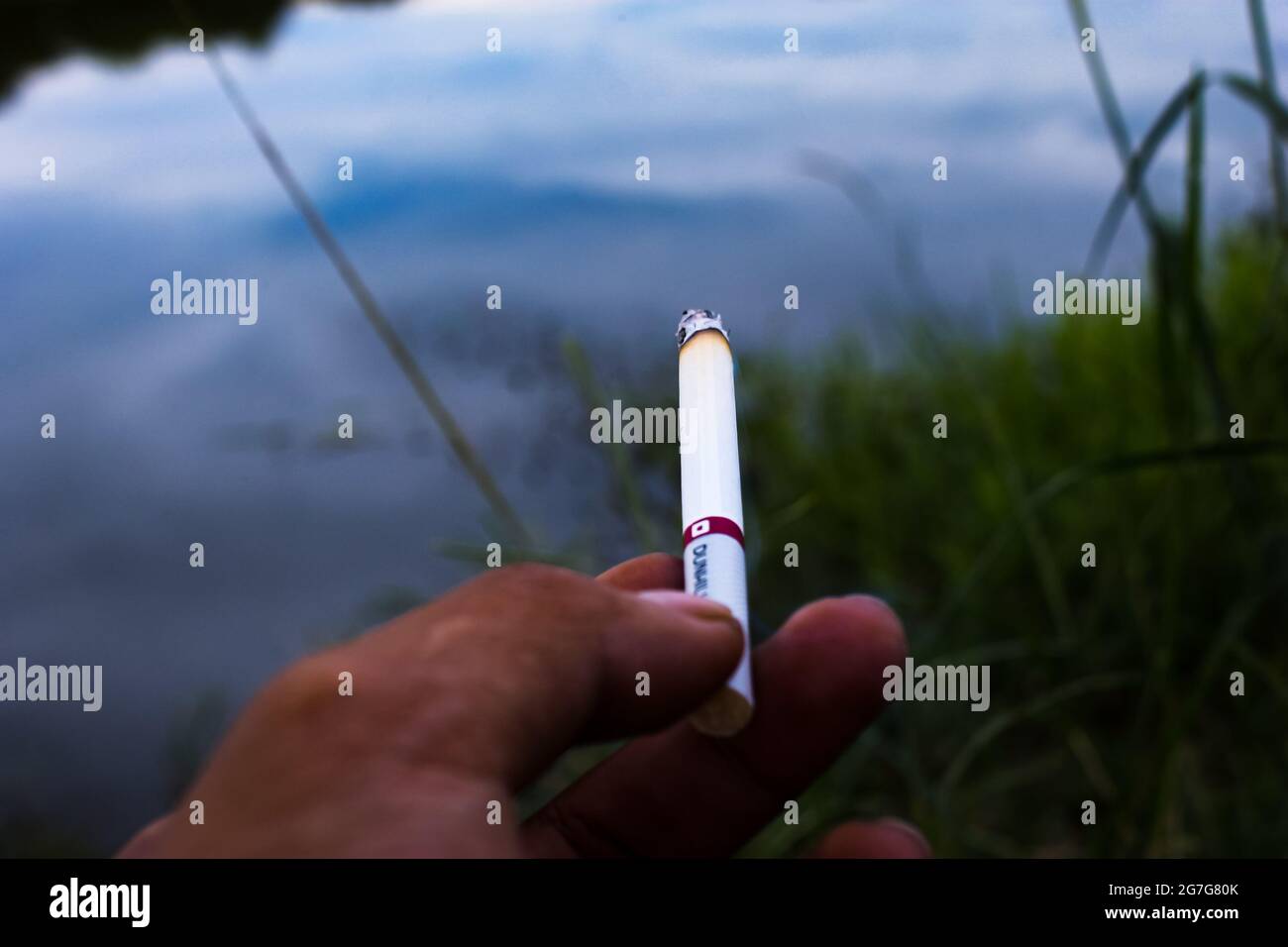 Eine Zigarette, die am See geraucht wurde Stockfoto