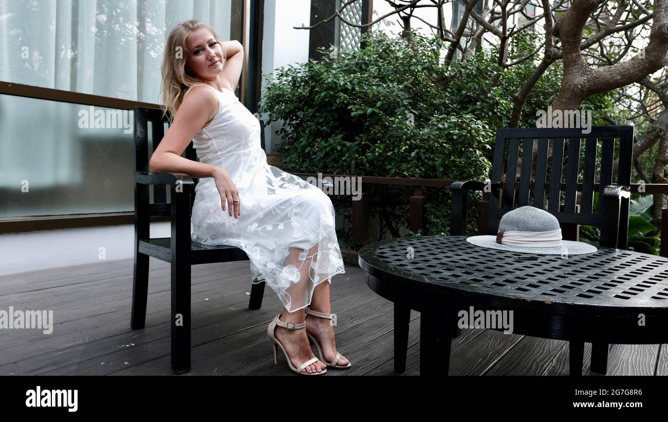 Osteuropäische kaukasische Frau mittleren Alters blondes Haar helle Haut blassen Teint tragen weißes Sommerkleid Lässige Kleidung Tag posiert Stockfoto