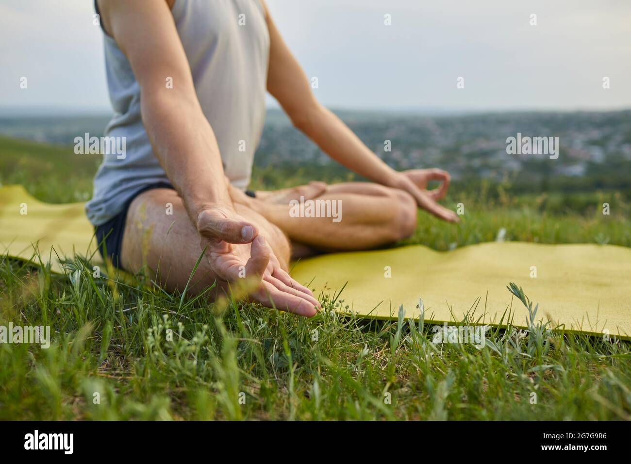 Anonymer männlicher Yogi, der sich entspannt und inneren Frieden erreicht, während er Yoga in der Natur praktiziert Stockfoto