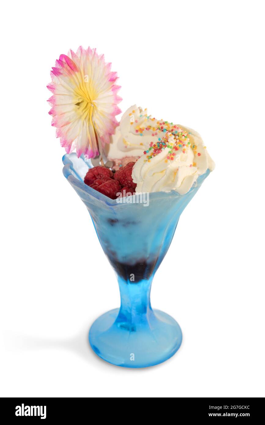 Eiscreme mit Himbeeren in blauer Glasschale mit farbenfroher Papierblumen-Dekoration isoliert auf weißem, kopiertem Raum Stockfoto