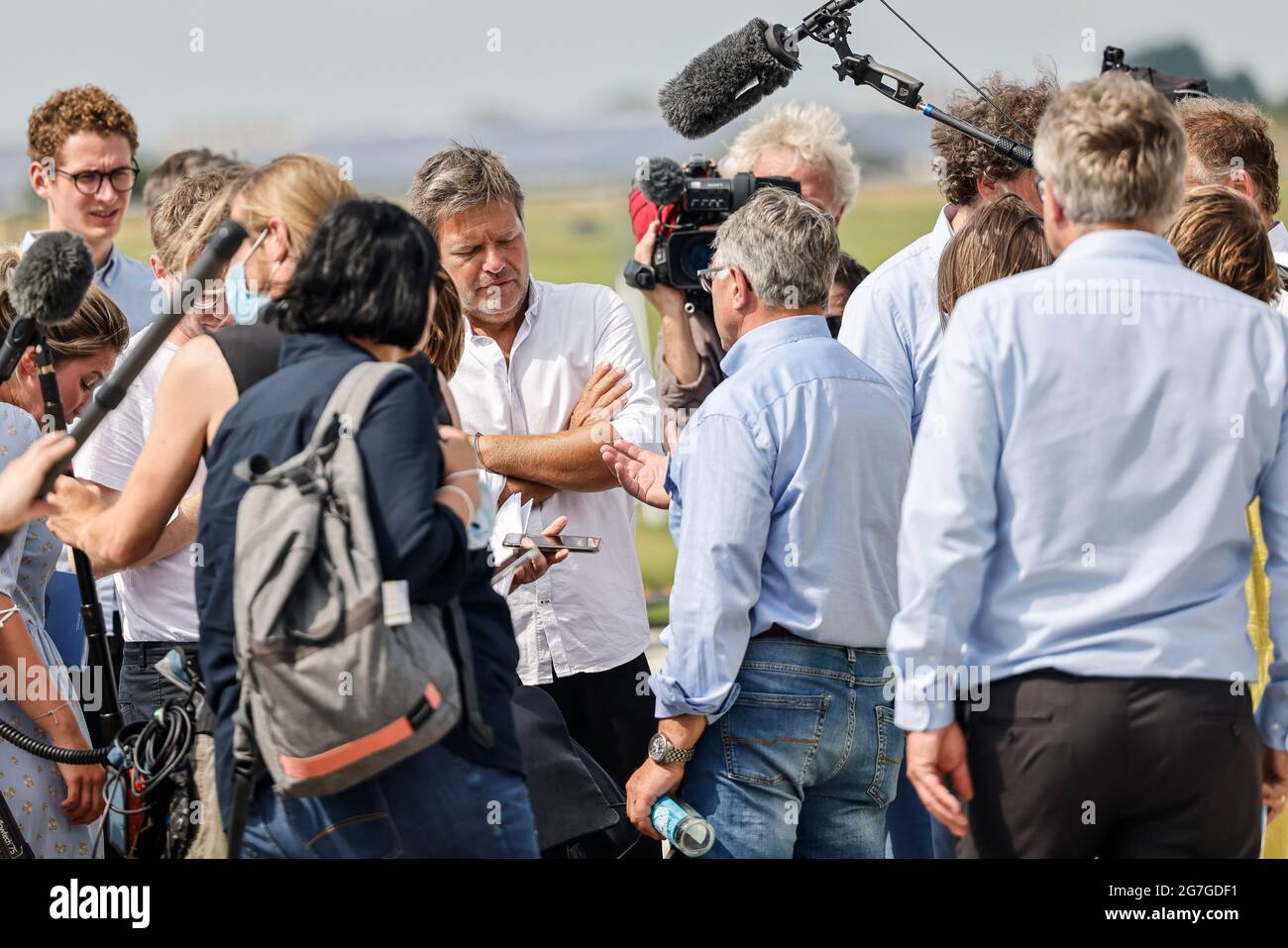 12. Juli 2021, Schleswig-Holstein, Klixbüll: Robert Habeck (M, Bündnis 90/die Grünen) spricht am Rande einer Wahlkampfveranstaltung im Landkreis Nordfriesland mit Journalisten. Bis zum 30. Juli 2021 ist der Politiker als Spitzenkandidat und Co-Bundesvorsitzender seiner Partei auf einer Küstenreise in Schleswig-Holstein. Foto: Frank Molter/dpa Stockfoto