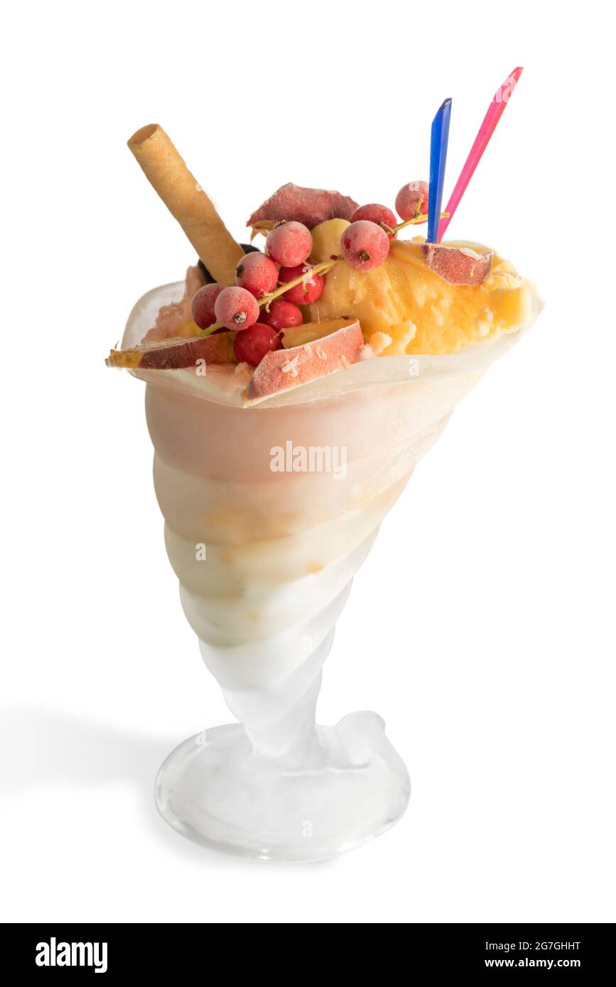 Pfirsich-Eis in Füllhorn-Glas mit Pfirsichscheiben und roter Johannisbeere isoliert auf weiß Stockfoto