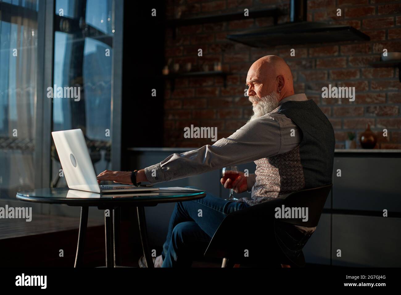 Männlicher Freiberufler arbeitet nachts auf einem Laptop. Stockfoto