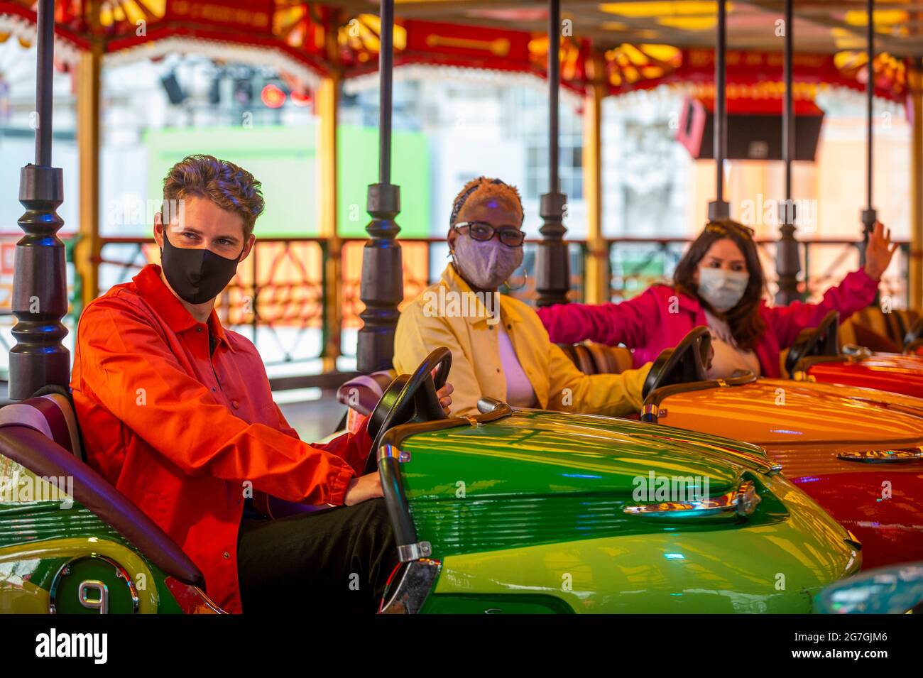 London, Großbritannien. 14. Juli 2021. Models posieren in Dodgem-Autos in DODGE, einem großen, funktionierenden Dodgem-Autoritt-Setup im Innenhof des Somerset House für den Sommer. Die Fahrt sowie die gesellschaftlich distanzierten Nahrungsmittel- und Getränkeschoten in der Nähe sind vom 15. Juli bis 22. August für die Öffentlichkeit zugänglich. Kredit: Stephen Chung / Alamy Live Nachrichten Stockfoto