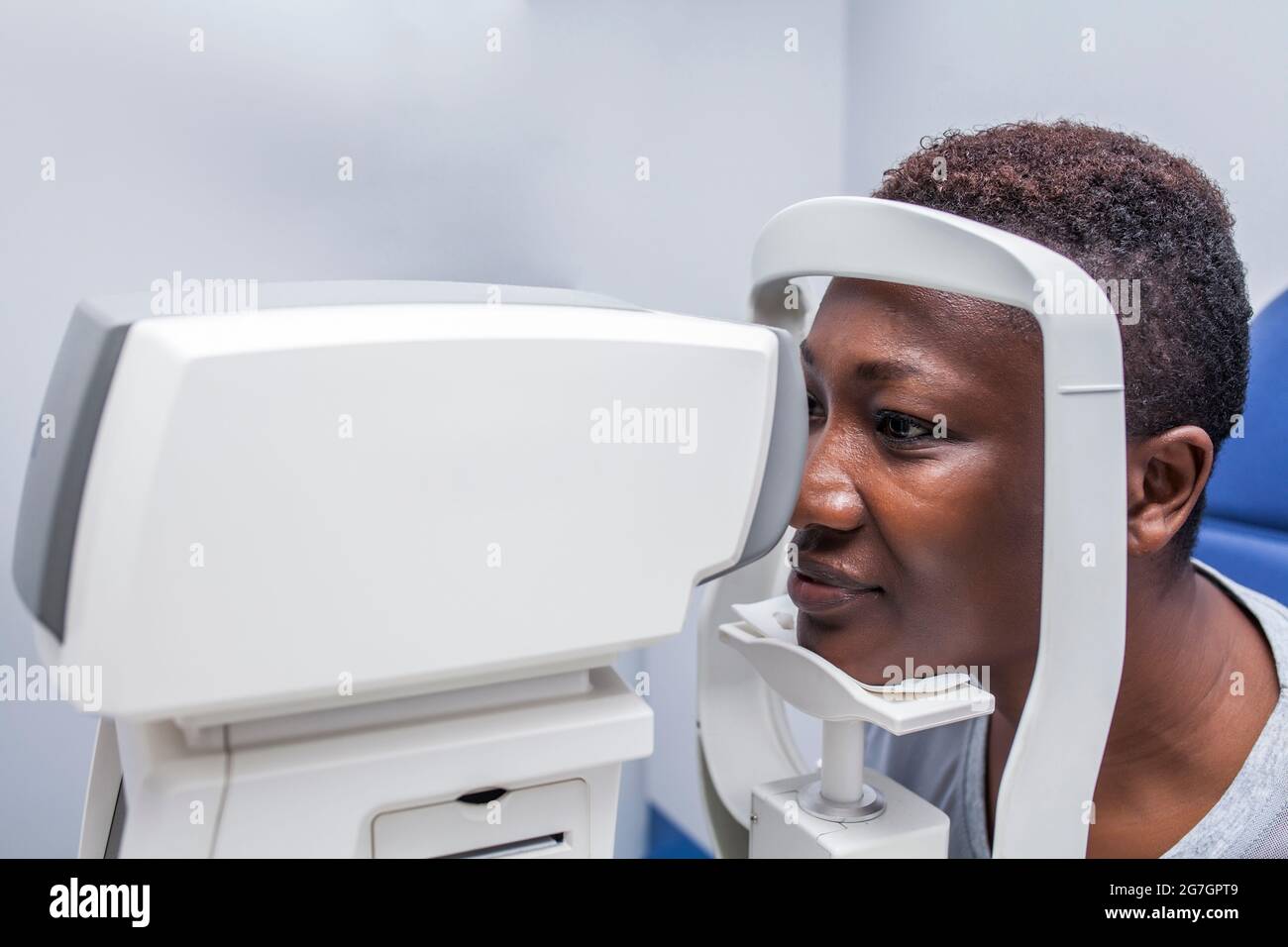 Schwarze Frau in Optometrieschrank während der Untersuchung des Sehvermögens mit einem modernen Retinograph Stockfoto