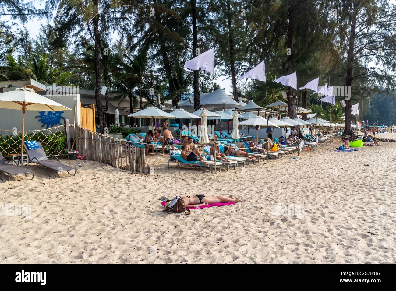 Phuket Thailand - 8. Februar 2021: Touristen sonnen sich im Catch Beach Club am Strand von Bang Tao . Stockfoto