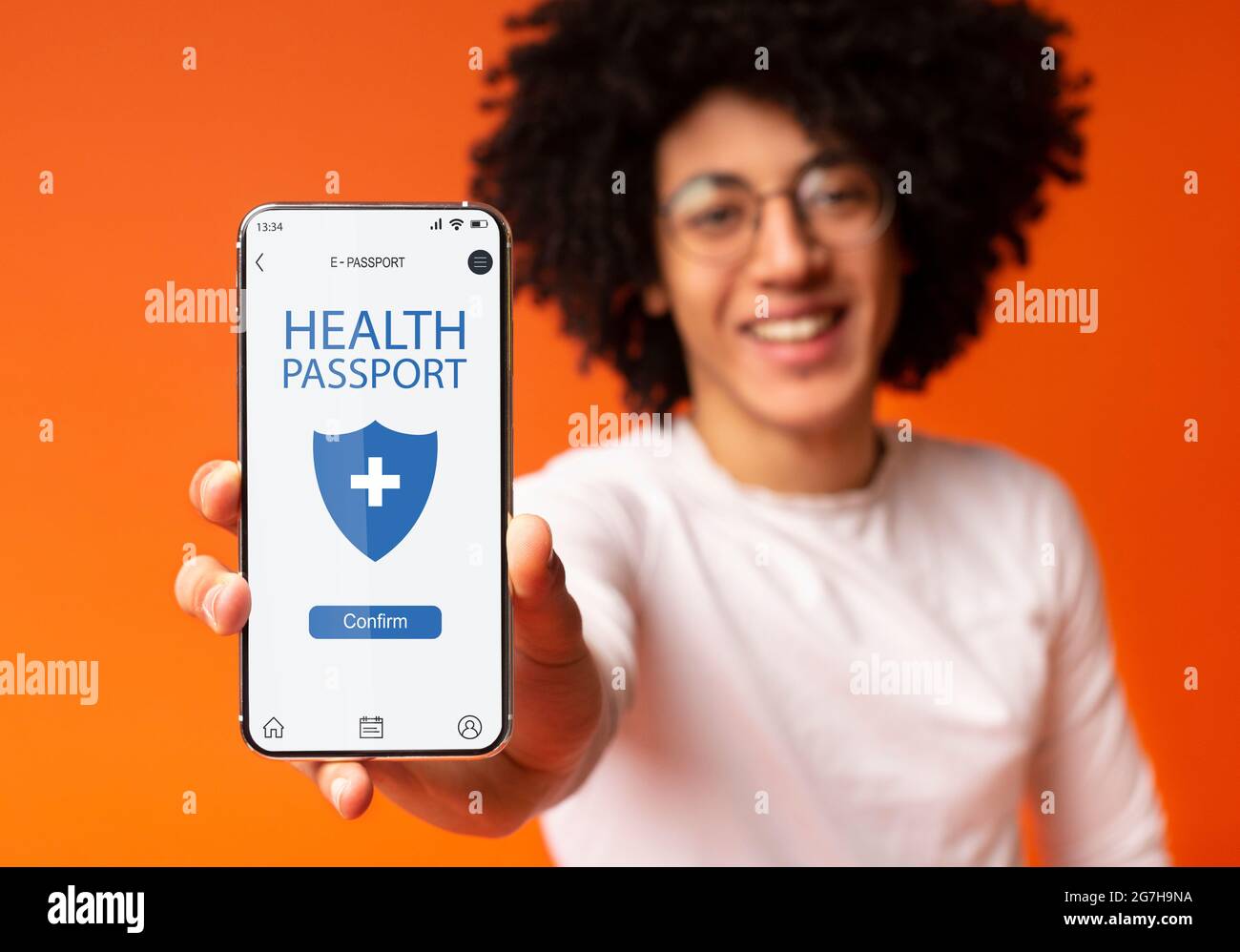 Elektronischer Health Pass. Afroamerikanischer Teenager, der sein Mobiltelefon mit digitalem E-Pass in der Hand hält und die mobile Anwendung auf dem Bildschirm zeigt, was dies bestätigt Stockfoto