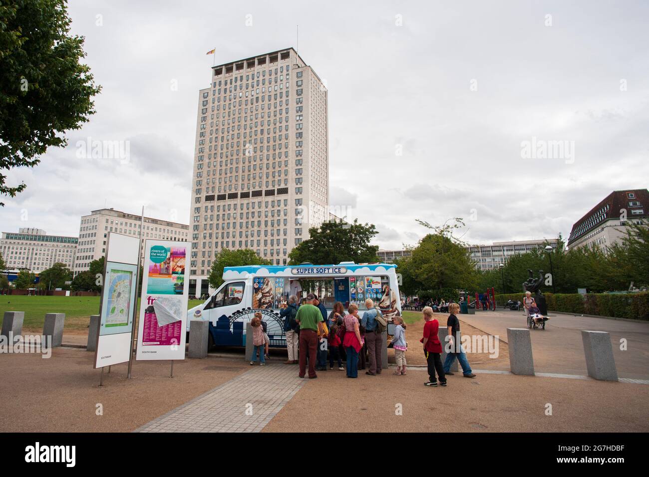 London, England. Eltern und Kinder kaufen Eis in einem Eiswagen, der vor dem Hauptsitz von Royal Dutch Shell in London geparkt ist Stockfoto