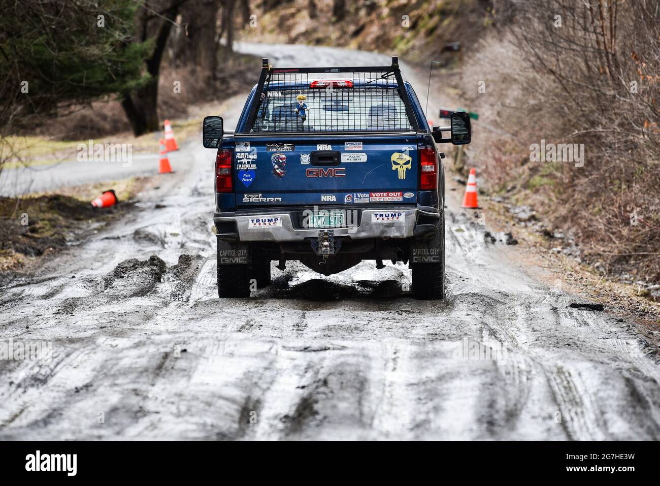 LKW mit Donald Trump Schilder verhandeln schlammigen, schneebedeckten Feldweg während der Schlammsaison in Vermont, Neuengland, USA. Stockfoto