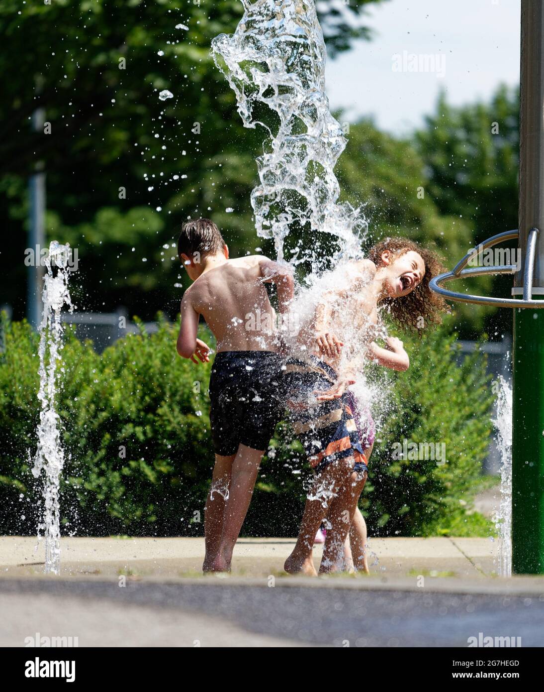 Drei Kinder spielen in Quebec City, Kanada, Wasserspiele und Springbrunnen Stockfoto