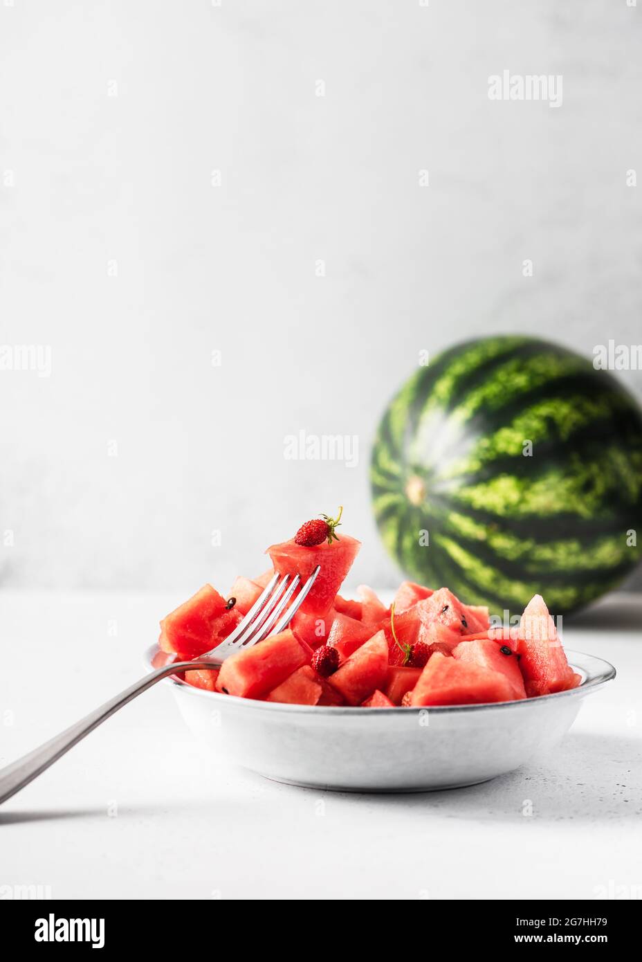Schüssel mit Bio-Wassermelone Stücke mit wilden Erdbeeren für eine gesunde Ernährung auf Küchentisch. Speicherplatz kopieren. Stockfoto