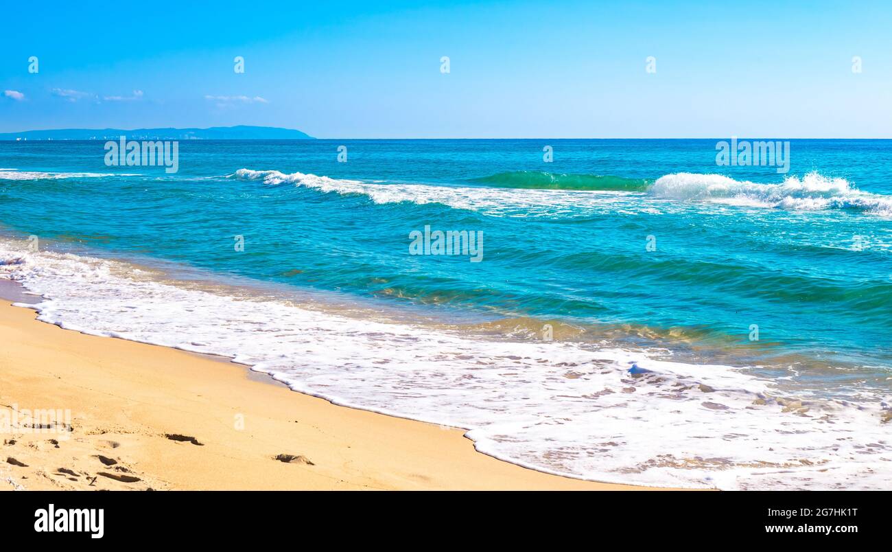 Blaues Meer mit einer schäumenden Welle und einem Sandstrand. Sommerpanorama der Natur. Stockfoto