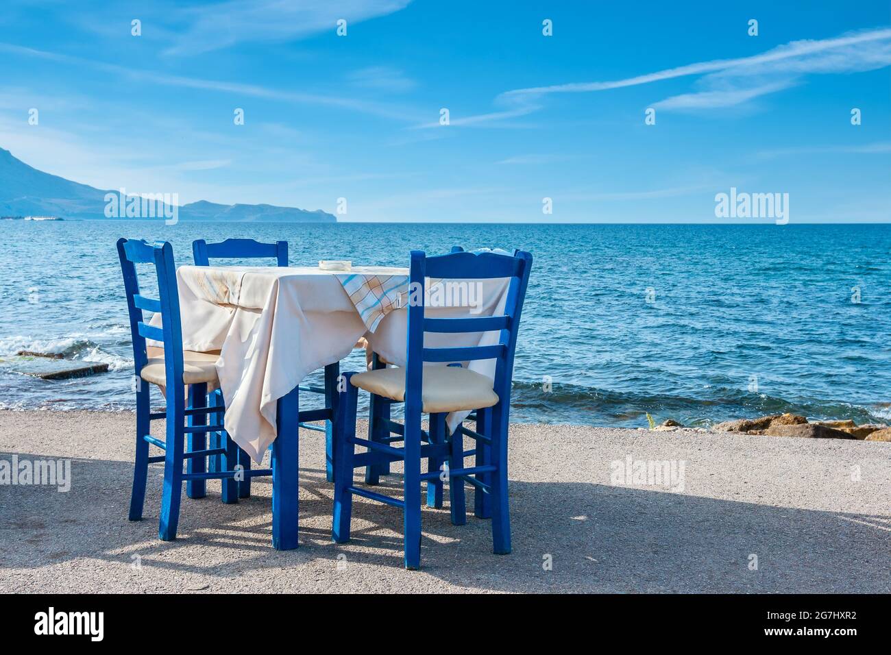 Blaue Stühle und Tisch in einer typisch griechischen Taverne in der Nähe des Meeres in Kissamos. Kreta, Griechenland Stockfoto